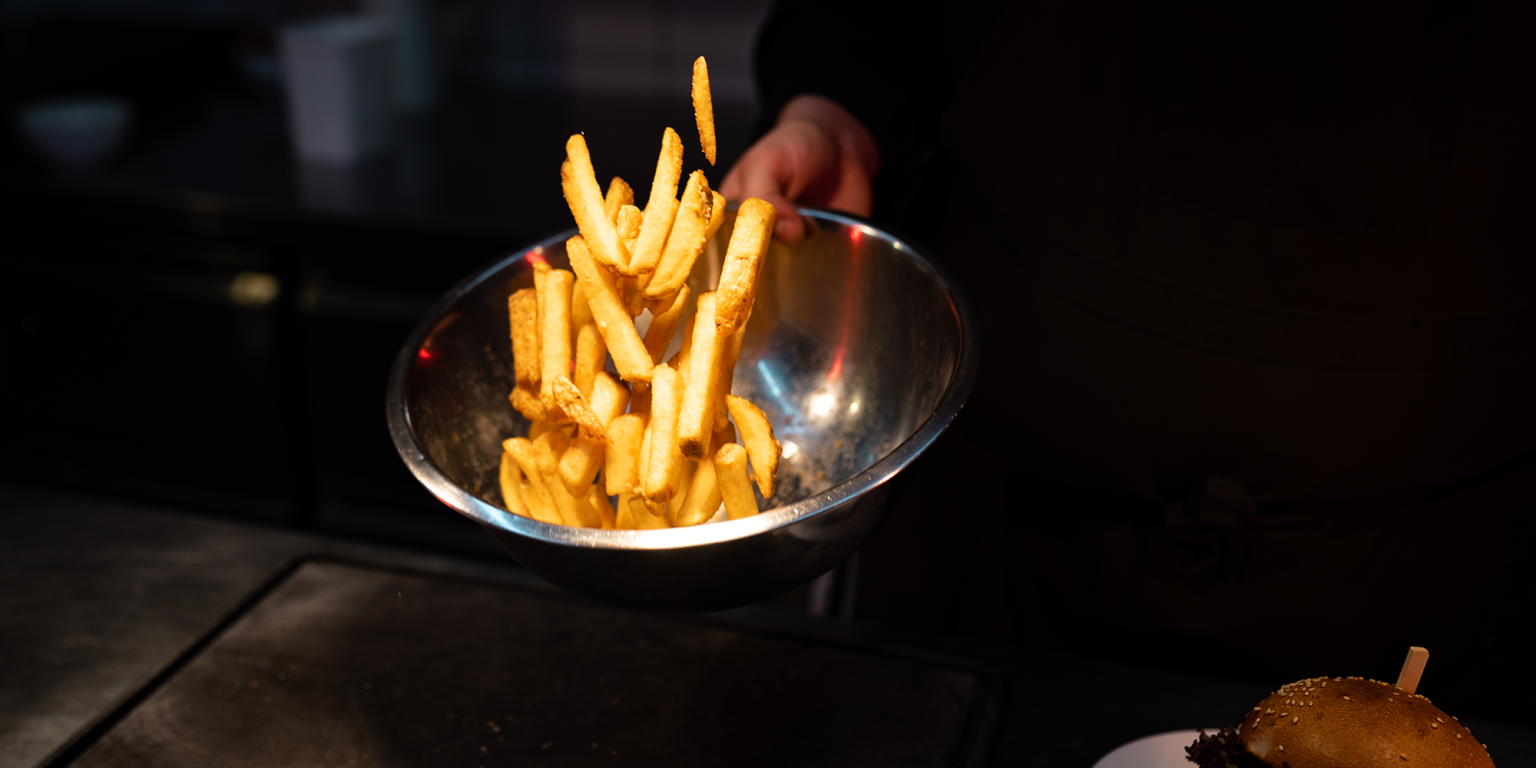 Ein Bild von knusprigen Pommes in der Produktion, fotografiert während eines Food-Fotoshootings für Tommy's Braterei. Hochauflösende Fotografie für Social Media von JNPhotografics.