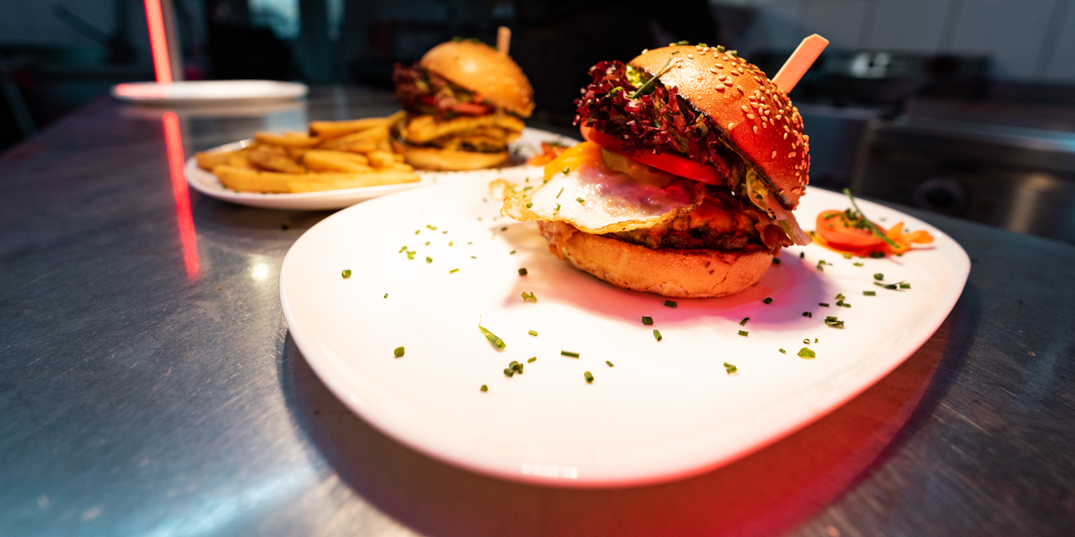 Ein Bild von einem köstlichen Gourmet-Burger, fotografiert während eines Gastronomie-Fotoshootings für Tommy's Braterei in Bad Kissingen. HQ-Fotoproduktion für Social Media durch JNPhotografics.