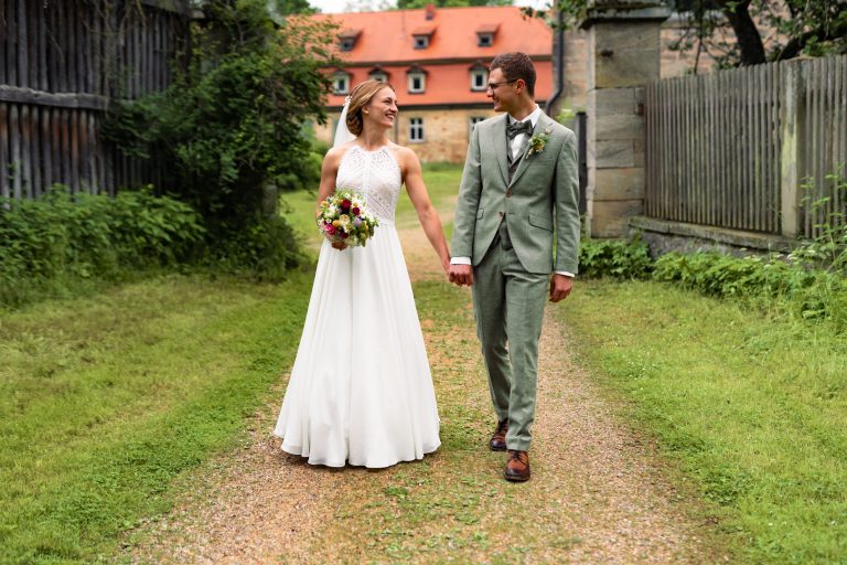 Braut mit Blumenstrauß vor historischer Kulisse in Bad Kissingen – Hochzeitsfotografie mit Eleganz und High-End-Qualität.