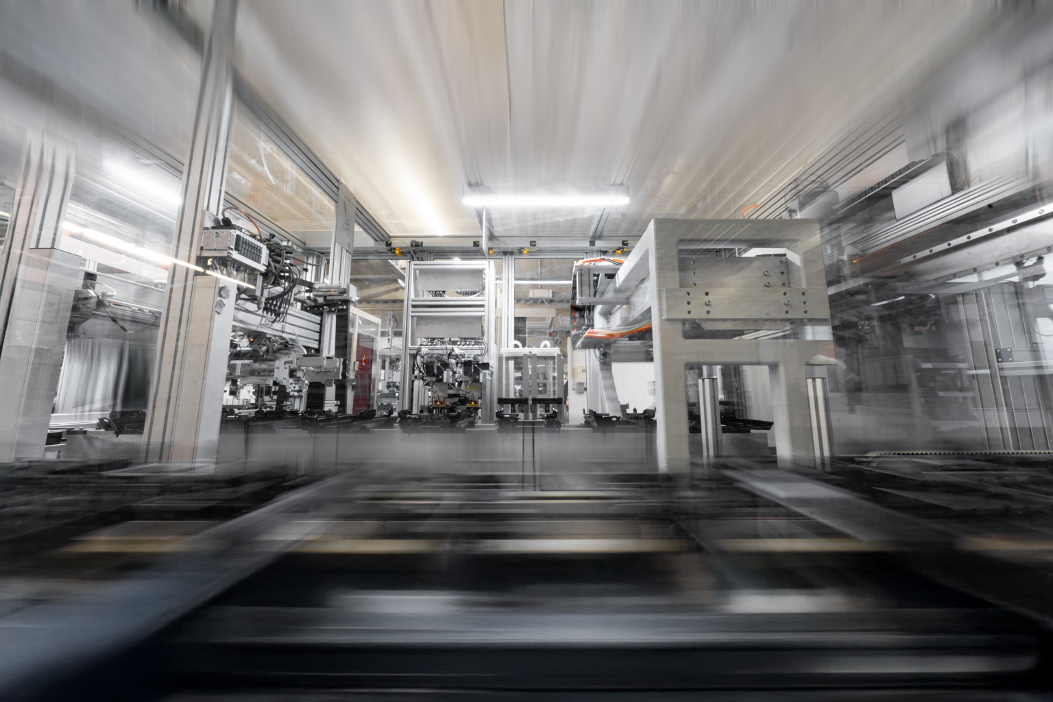 Langzeitbelichtung einer automatisierten Produktionslinie in moderner Industrieumgebung: Bewegungsunschärfen visualisieren die hohe Geschwindigkeit und Effizienz des Fertigungsprozesses. Die Lichtspuren der Anlagen betonen die Dynamik und technologische Präzision. Diese Industrie Fotografie von Johannes Nöth | JNPhotografics.de fängt den Puls der Produktion in beeindruckender Bildsprache ein – ideal für die Darstellung von Automatisierung, Prozessoptimierung und moderner Fertigungstechnologie in Industriekommunikation und Employer Branding.