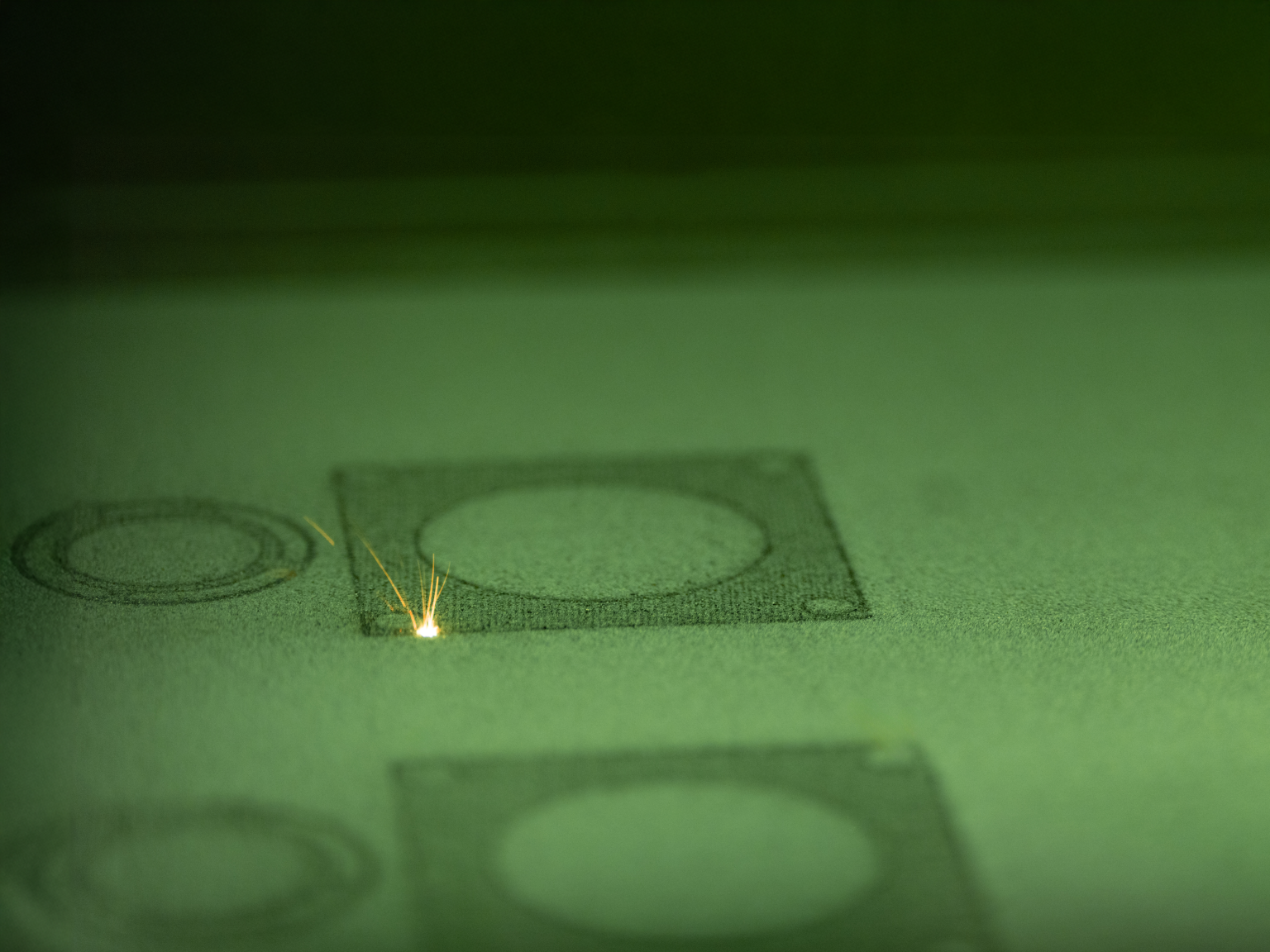Industrie Fotografie eines präzisen Lasersystems im Einsatz beim Metall-3D-Druck: Der Laserstrahl trifft punktgenau auf das Werkstück und verschmilzt das Metallpulver Schicht für Schicht. Die Szene wirkt futuristisch und technisch anspruchsvoll – ein Symbol für moderne Fertigungstechnologie und industrielle Innovation. Fotografiert von Johannes Nöth | JNPhotografics.de mit modernster Kameratechnik, zeigt dieses Bild die faszinierende Präzision des Laserschweißens im Bereich der additiven Fertigung. Ideal zur Darstellung von Hightech-Prozessen in der Industriekommunikation.