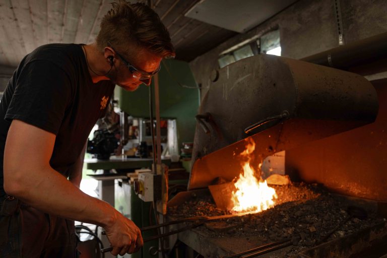 Imagefotografie in der Steinhofschmiede mit Schmied bei der Arbeit am Amboss und der Bearbeitung von Metall.