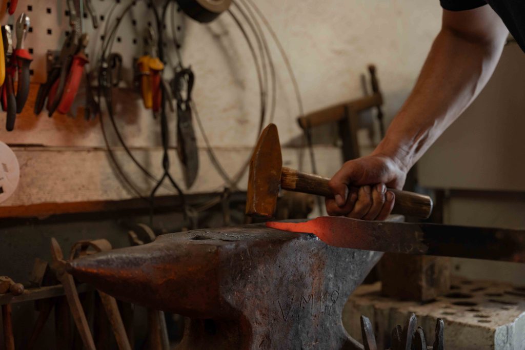 Imagefotografie in der Steinhofschmiede mit Hammerarbeit am Amboss beim Bearbeiten von glühendem Metall.