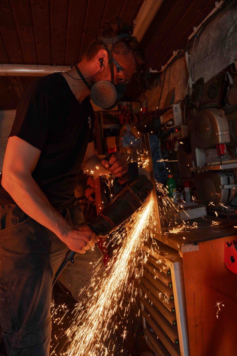 Imagefotografie in der Steinhofschmiede mit Flexarbeiten und starkem Funkenflug beim Bearbeiten von Metall.