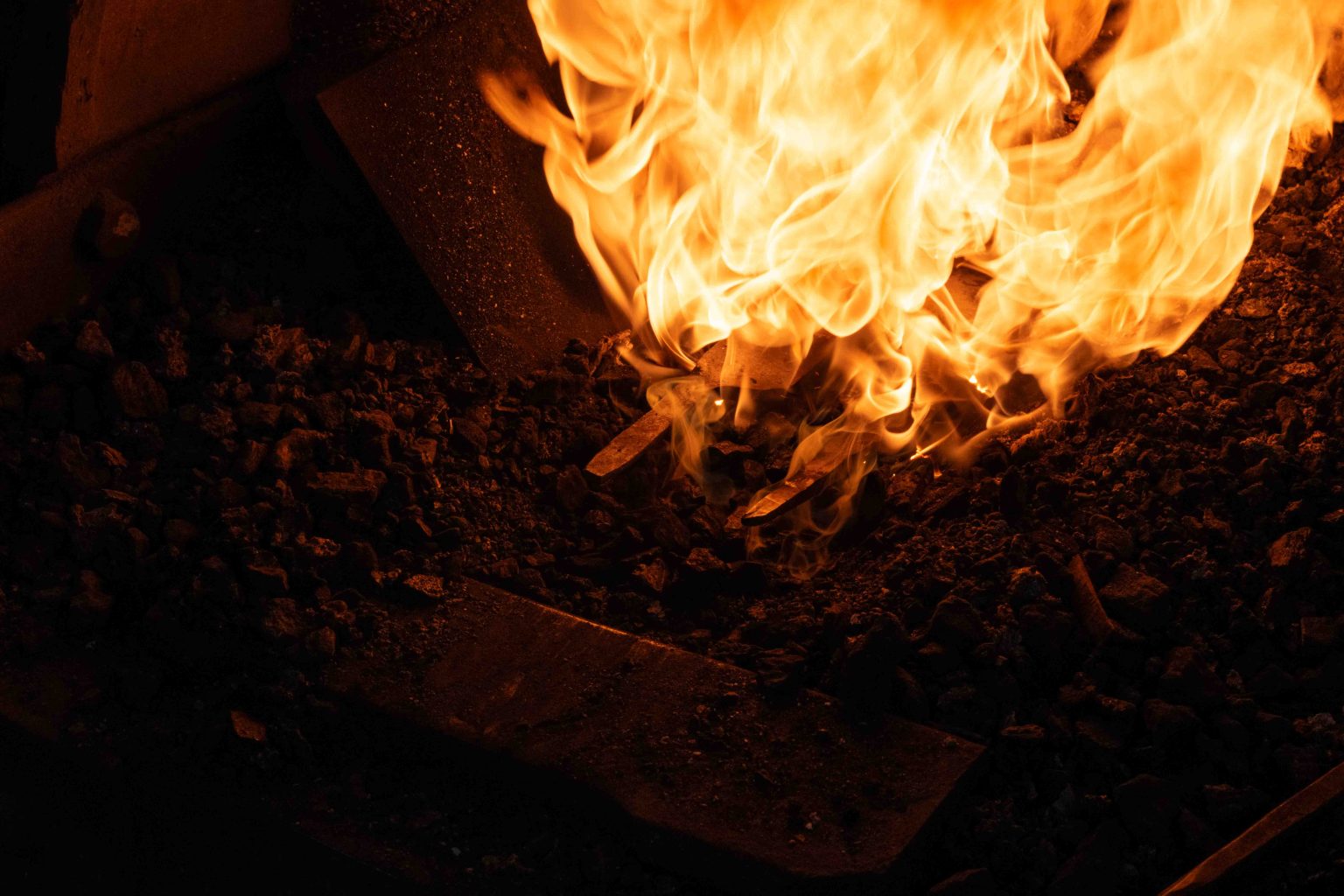 Imagefotografie in der Steinhofschmiede mit Messerschmied bei der Arbeit am Schmiedefeuer und glühendem Metall.